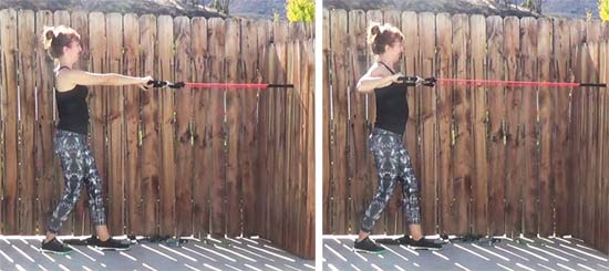 Personal trainer performing standing row with resistance band