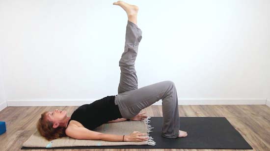 yoga teacher in single leg hip bridge exercise