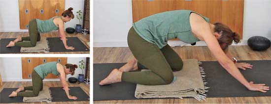 yoga teacher dressed in green on all fours on a  yoga mat