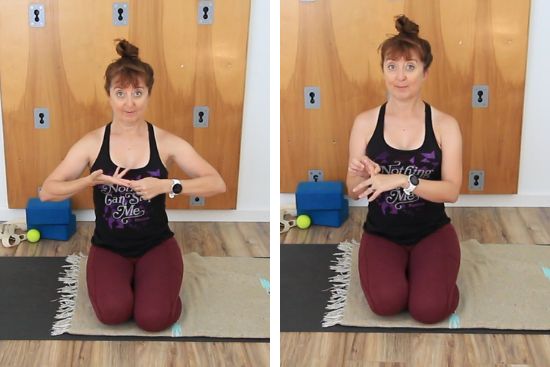 yoga teacher sitting on yoga mat demonstrating hand and finger stretches